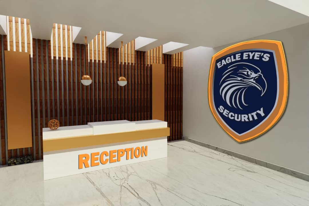 eight members of the Eagle Eye's team behind a desk, 6 standing and 2 sitting, in front of a large Eagle Eye's Security sign